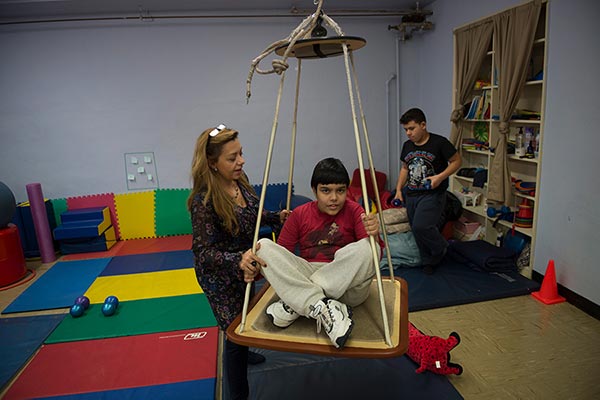 Gersh Academy Occupational Therapist Assists a Student in Therapy Swing