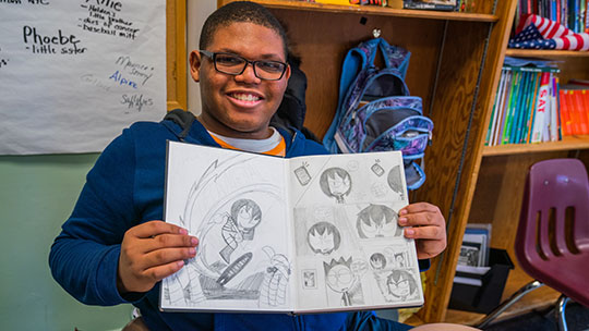 Gersh Academy Student Smiling and Showing off his Art Work